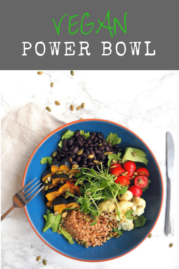 vegan power bowl featuring farro, roasted acorn squash, roasted cauliflower, black beans, grape tomatoes, pumpkin seeds, microgreens mixed greens, and a vinaigrette -- delicious, nourishing & satisfying