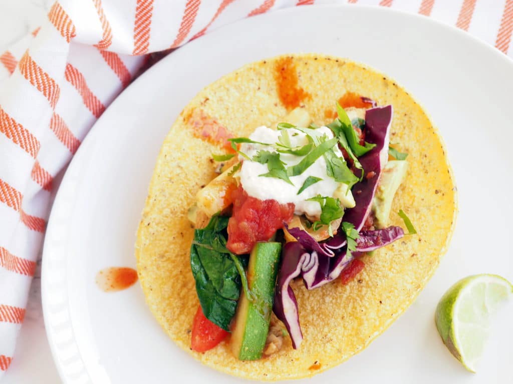 These chicken fajita tacos are a fun, healthy, and tasty addition to your taco Tuesday rotation. Packed with colorful veggies and easy to customize with your favorite veggies and toppings. Gluten-free and dairy-free without the sour cream topping.