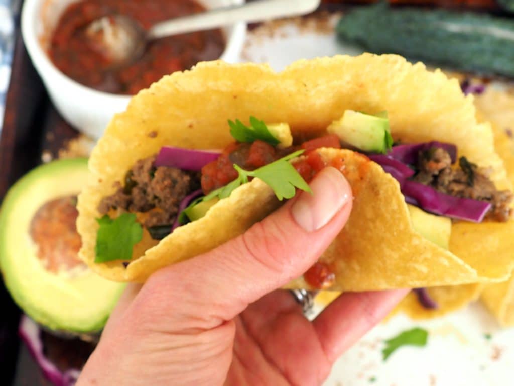 These family favorite beef and kale tacos are sure to be a hit at your dinner table! Plain grass fed ground beef gets a nutrient and flavor boost from fresh chopped onions and kale. This is a great way to get leafy greens into your kids! #glutenfree #dairyfree