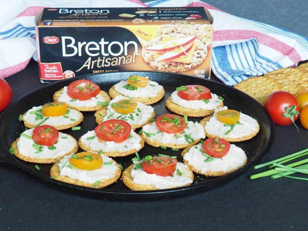#AD Need a healthy but simple appetizer idea for your next get-together? These crackers with white bean dip, tomatoes, and chives are perfect! Use summer fresh grape or cherry tomatoes for maximum flavor! #vegan From halsanutrition.com