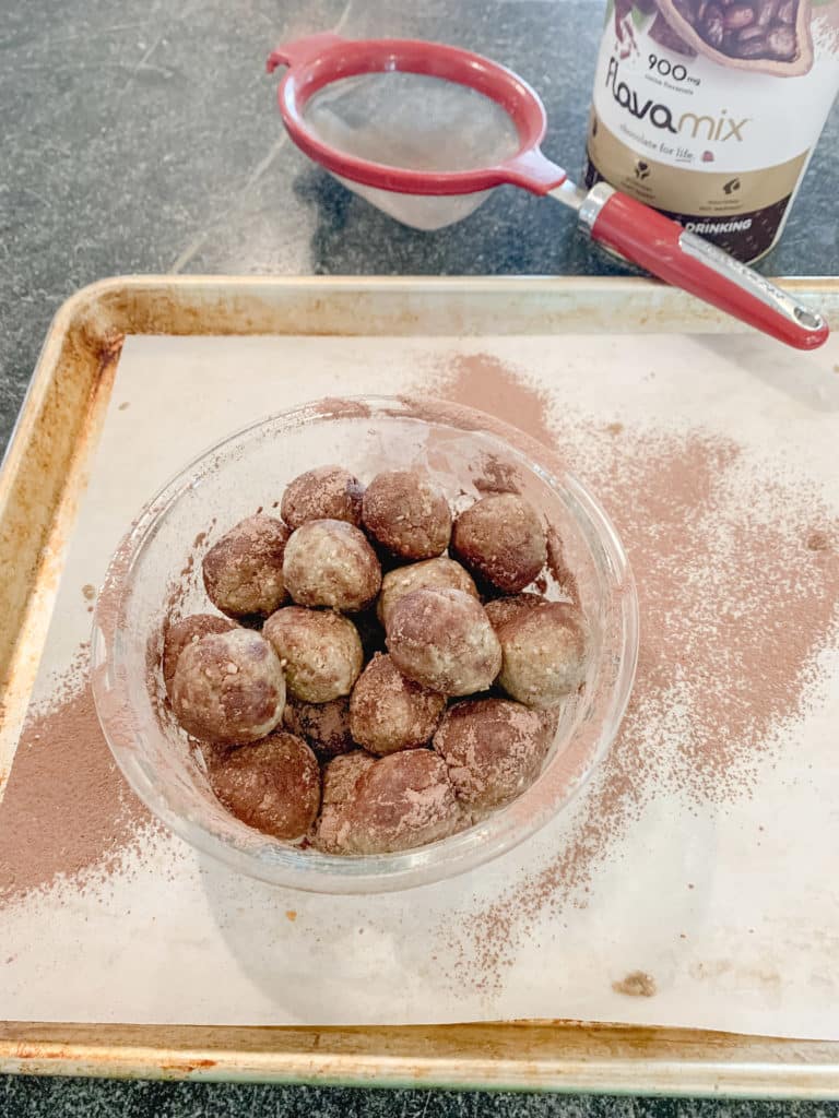 dusting sunflower seed energy balls with cocoa powder