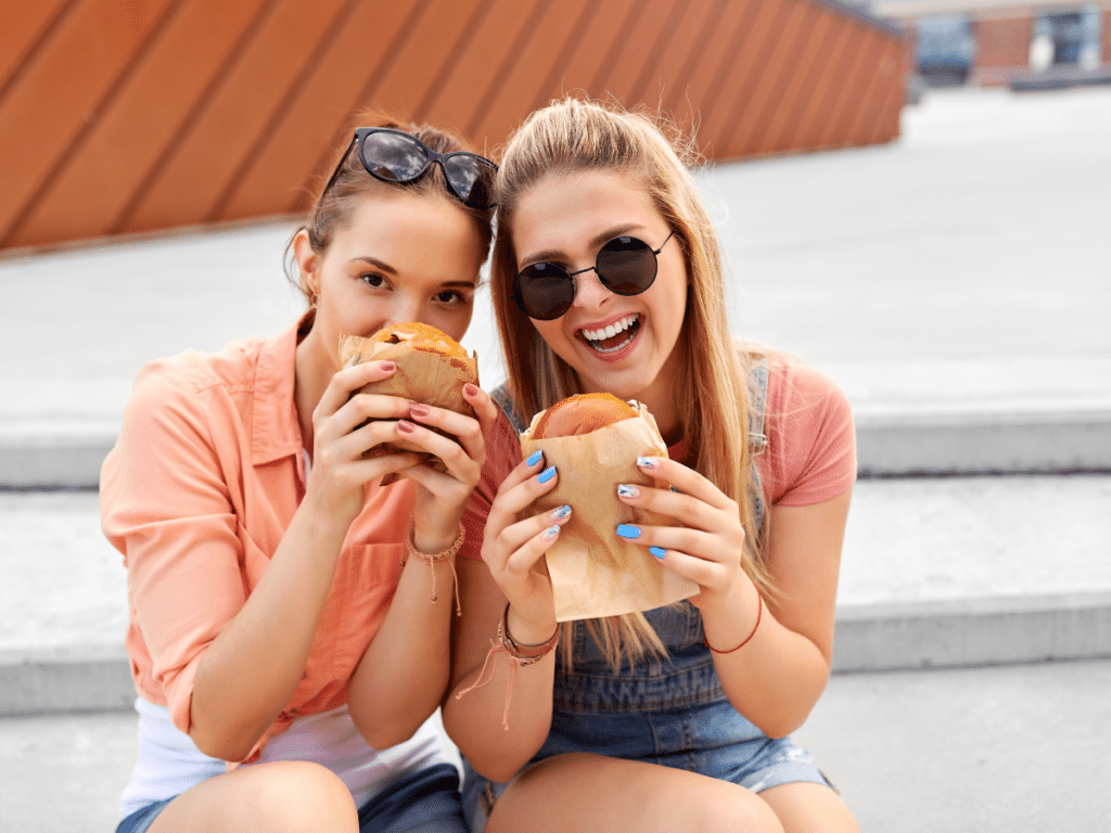 two young women enjoying burgers
